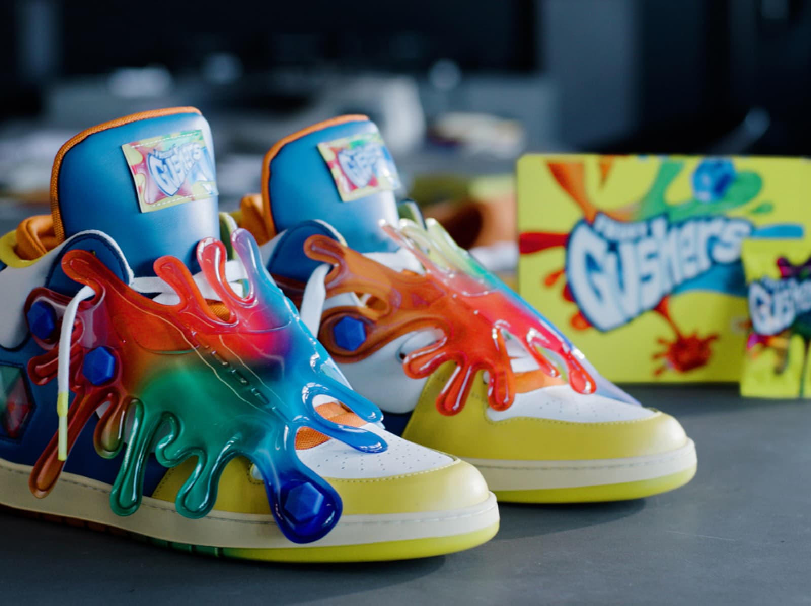Gushers designer sneakers next to a box of Gushers fruit snacks
